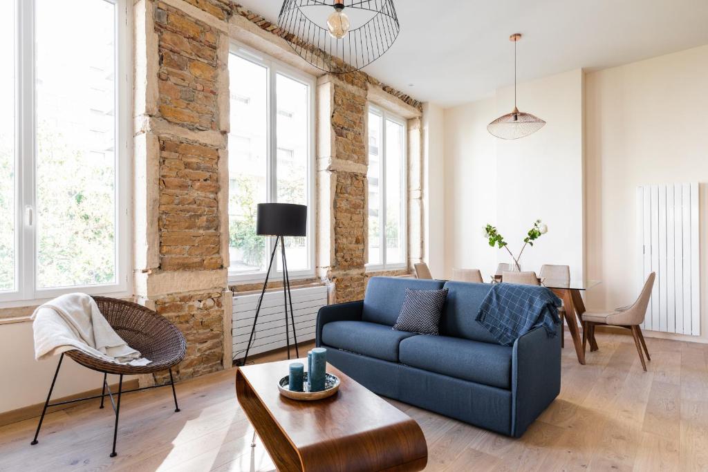 a living room with a blue couch and a table at DIFY Lumière - Masséna in Lyon