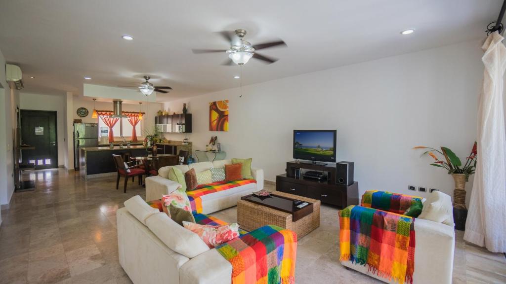 a living room with two couches and a tv at Playa Village 205 A condo in Playa del Carmen