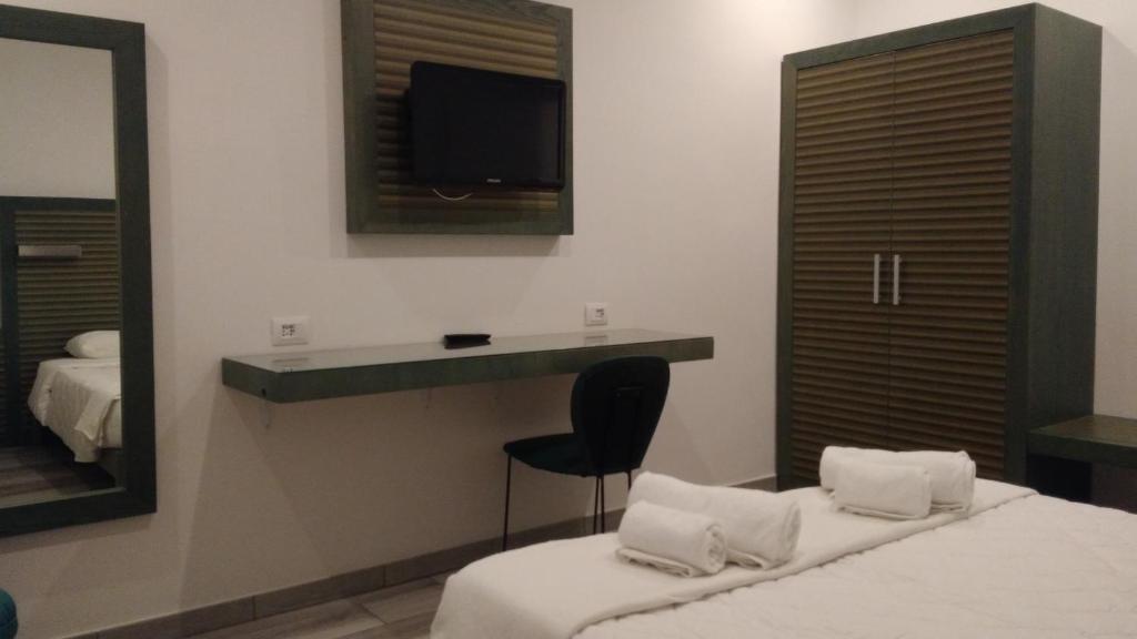 um quarto com uma cama, um espelho e uma televisão em Suite White em Turim