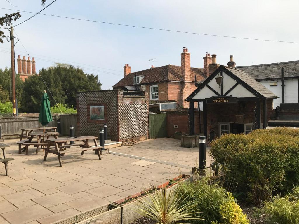 a patio with benches and tables in front of a building at Bull Inn in Reading