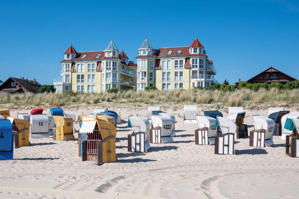 un mucchio di sedie sulla spiaggia con edifici sullo sfondo di Dünenresidenz mit Meerblick a Bansin