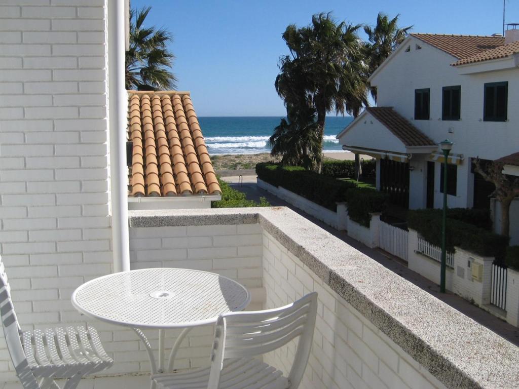 AT048 Gregal في كريكسل: طاولة بيضاء وكراسي على شرفة مع الشاطئ