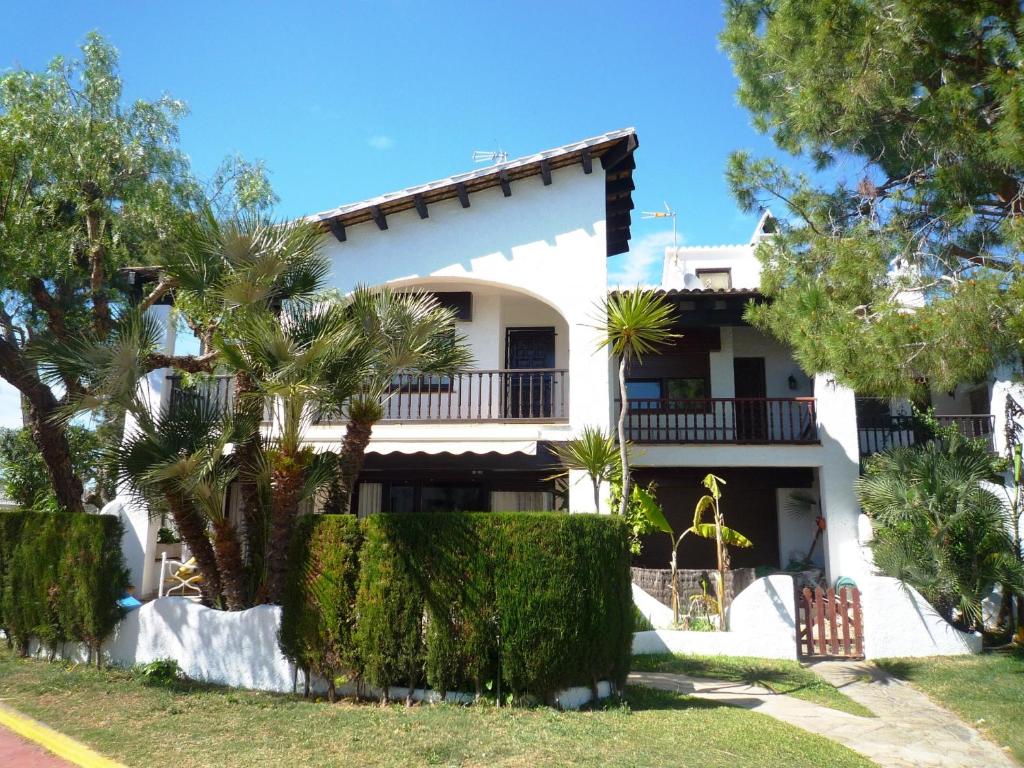 a white house with trees in front of it at Villa Service - Alorda park in Calafell