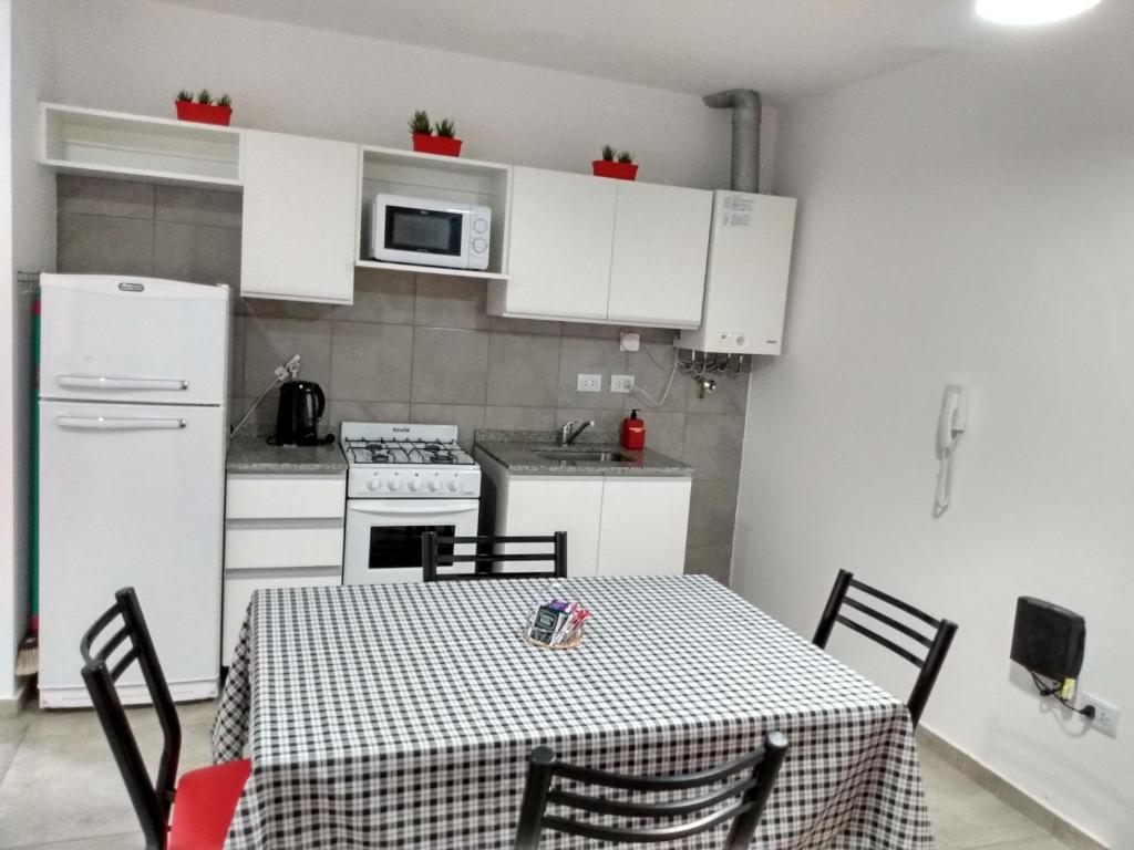 a kitchen with a table and a kitchen with white cabinets at La Recova in Alta Gracia