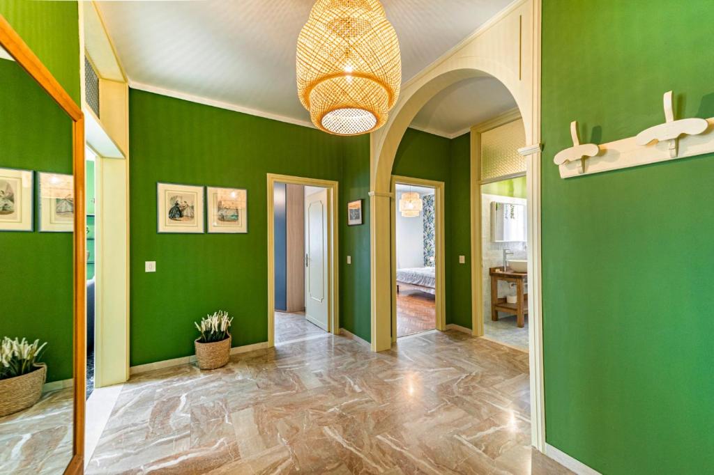 un corridoio con pareti verdi e lampadario a braccio di Novalesi Vintage a Noale
