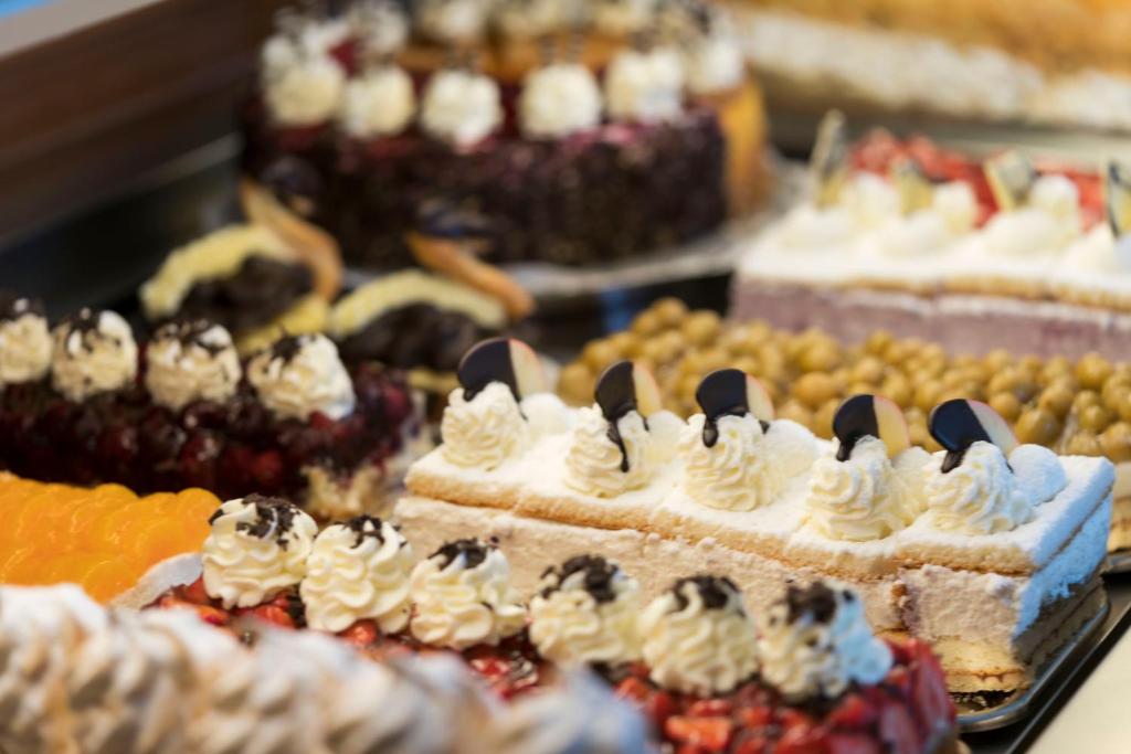a display of different types of cakes and other desserts at Hotel & Café Strandeck in Prerow