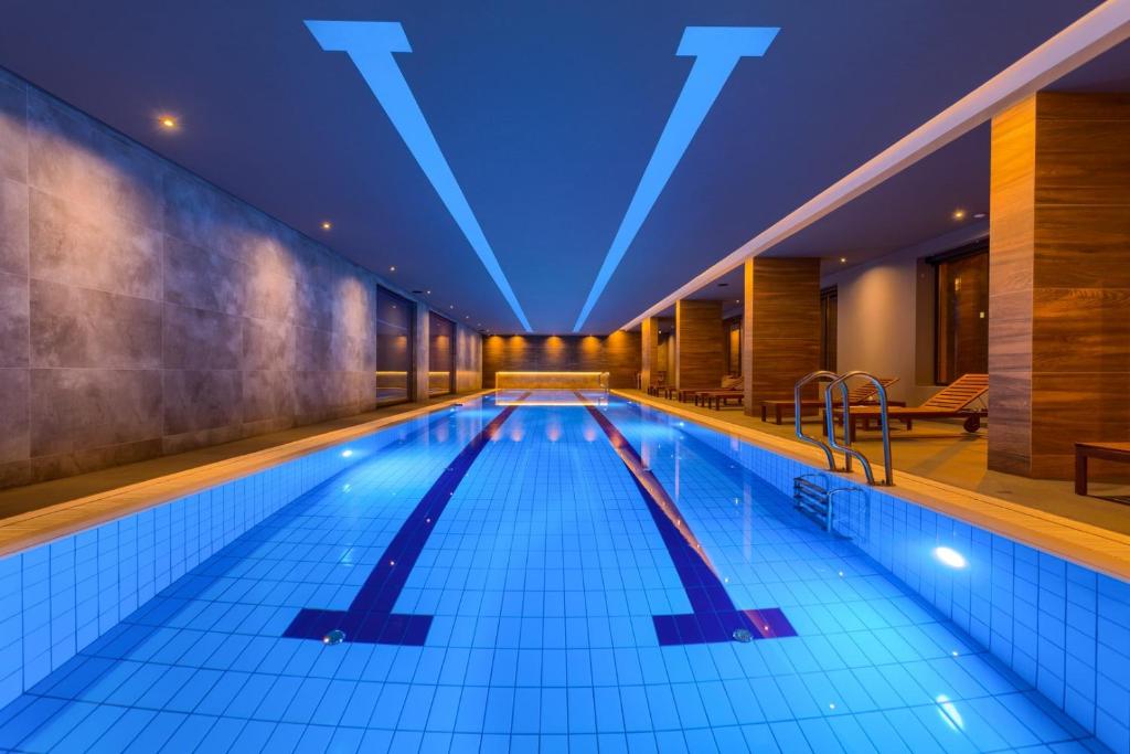 Kalman SPA&GYM في زلاتيبور: حمام سباحة كبير مع أضواء زرقاء في مبنى