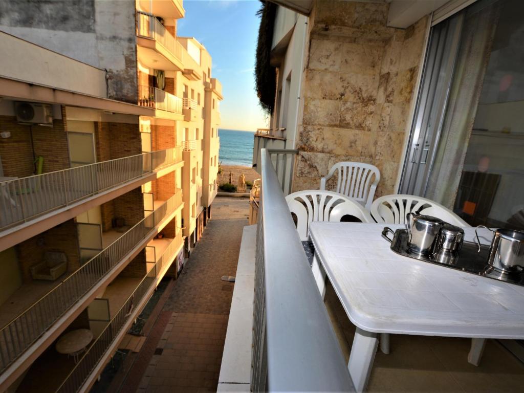 een tafel en stoelen op een balkon met uitzicht op de oceaan bij Villa Service - Suïssa 3 in Calafell