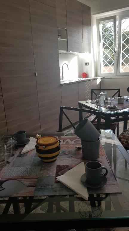 a kitchen with a table with bowls and cups on it at THAT'S AMORE FIUMICINO Airport in Fiumicino