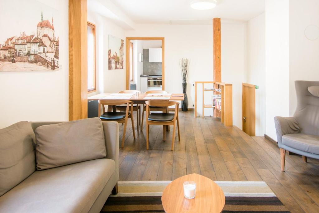 a living room with a couch and a table at Modern Apartment in a Picturesque 15th-Century Building in Prague