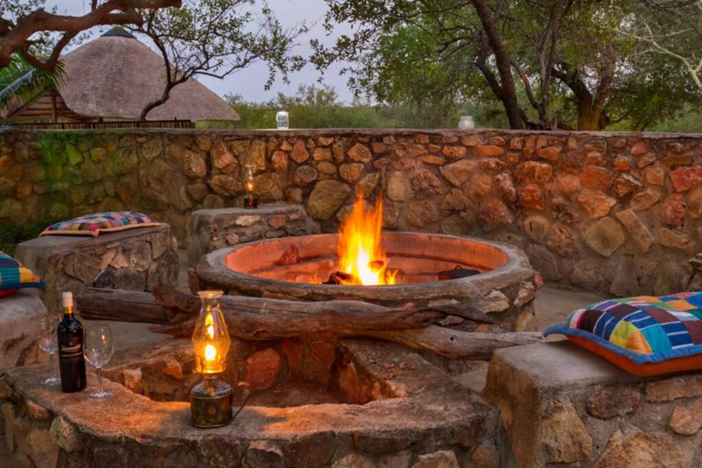 a fire pit in a stone wall with two bottles at Thornhill Guest House in the middle of a nature reserve in Hoedspruit