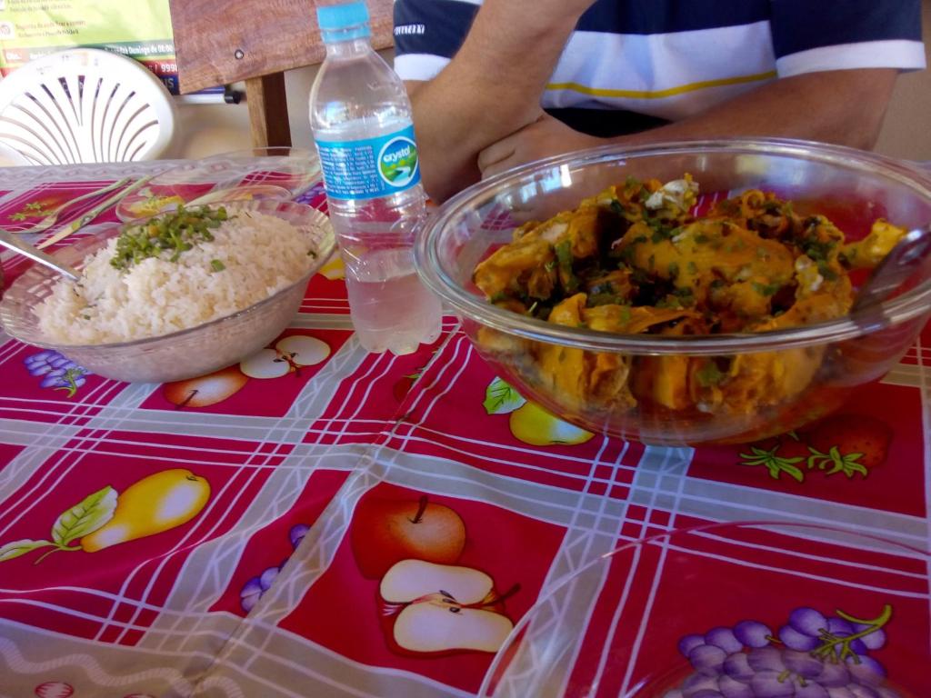 una mesa con un tazón de comida y un tazón de arroz en Rest. e Pousada Fabiao II, en Itacarambi