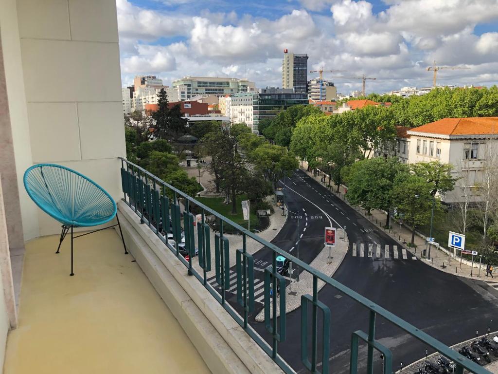 a blue chair sitting on the balcony of a building at Architectural poetry in an unique 3bdrs view flat in Lisbon