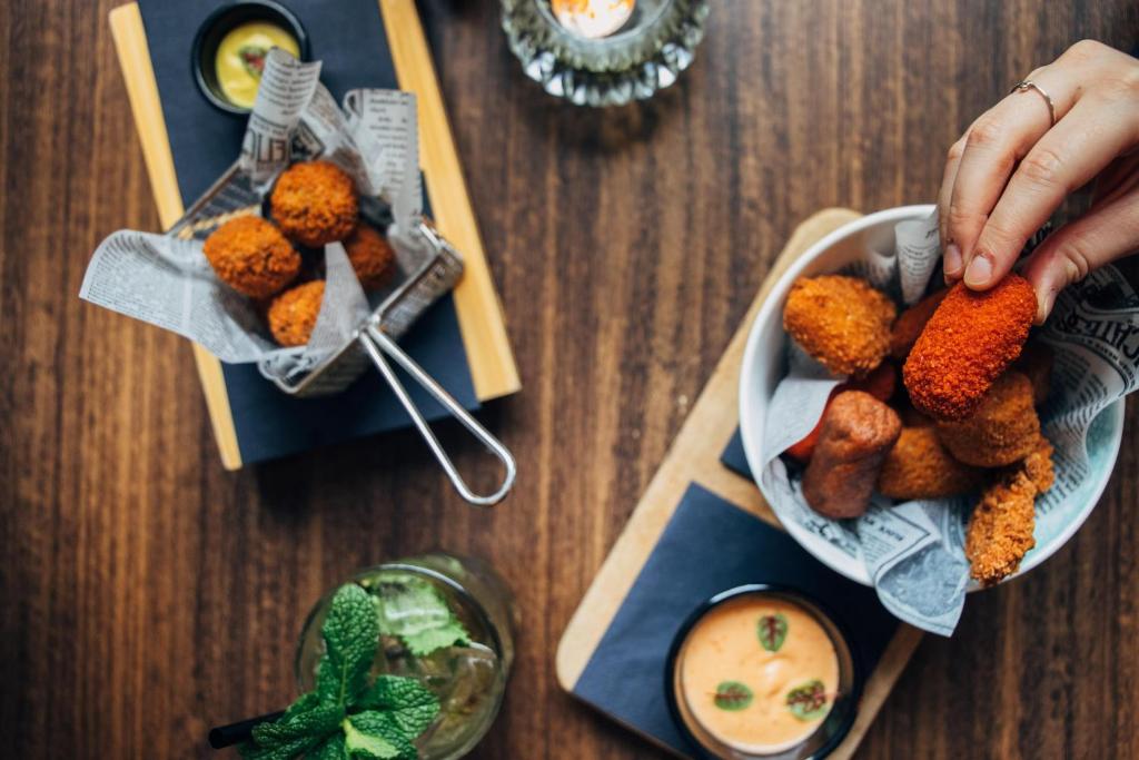 a person holding a plate of food on a table at Hotel ML in Haarlem