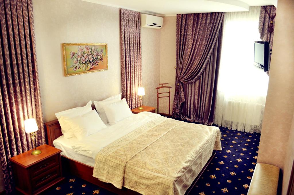 a hotel room with a bed and a window at Hotel Dobrodiy in Vinnytsya