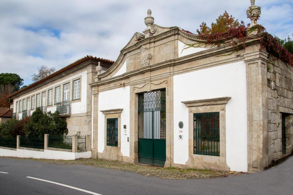 un vecchio edificio sul lato di una strada di Casa De Alfena a Póvoa de Lanhoso