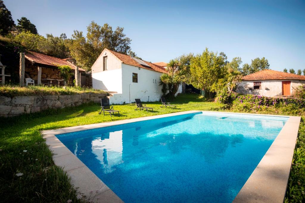 a swimming pool in the yard of a house at Casa de Santa Cristina in Alpendurada