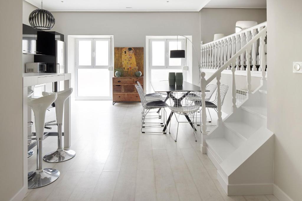 Colón by FeelFree Rentals في سان سيباستيان: غرفة طعام مع طاولة زجاجية ودرج أبيض