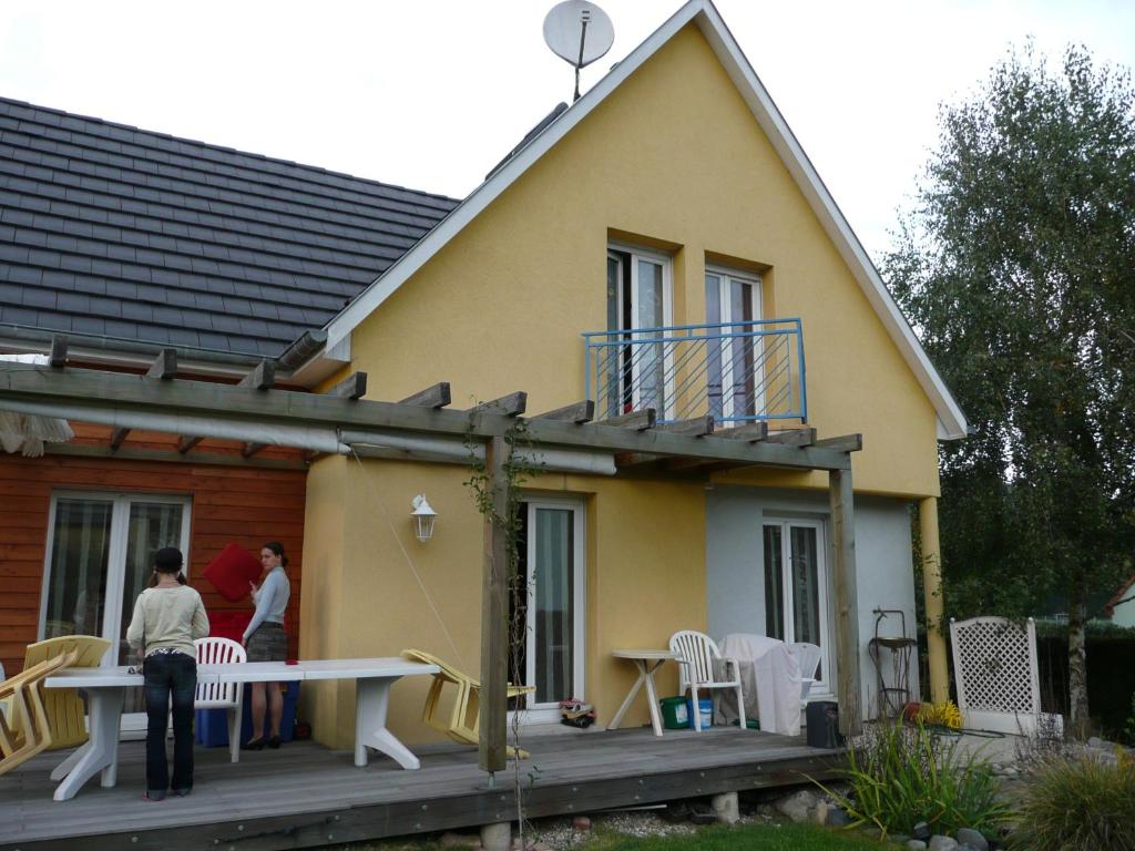dwoje ludzi stojących na ganku domu w obiekcie Alsace nature et découvertes w mieście Gunsbach