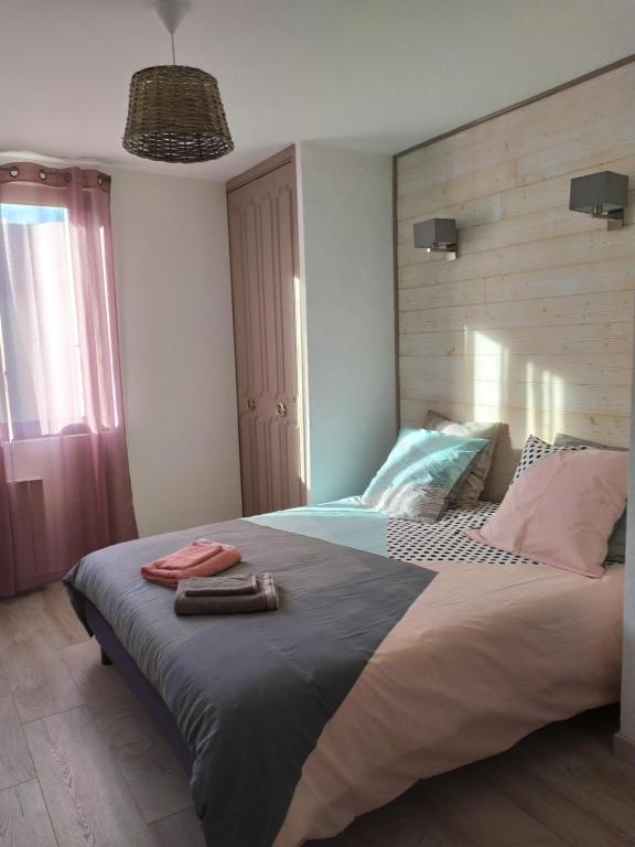 um quarto com uma cama grande e uma cabeceira em madeira em L'Atelier de Robert em Carcassonne