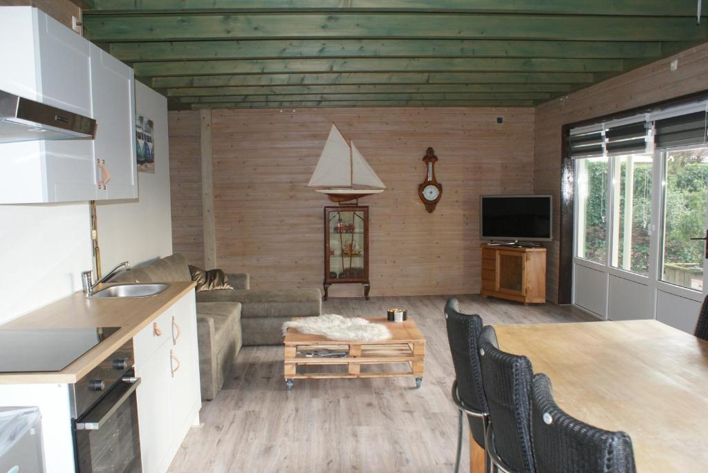 een keuken en een woonkamer met een bank en een tafel bij It Boat Hûs in Anjum