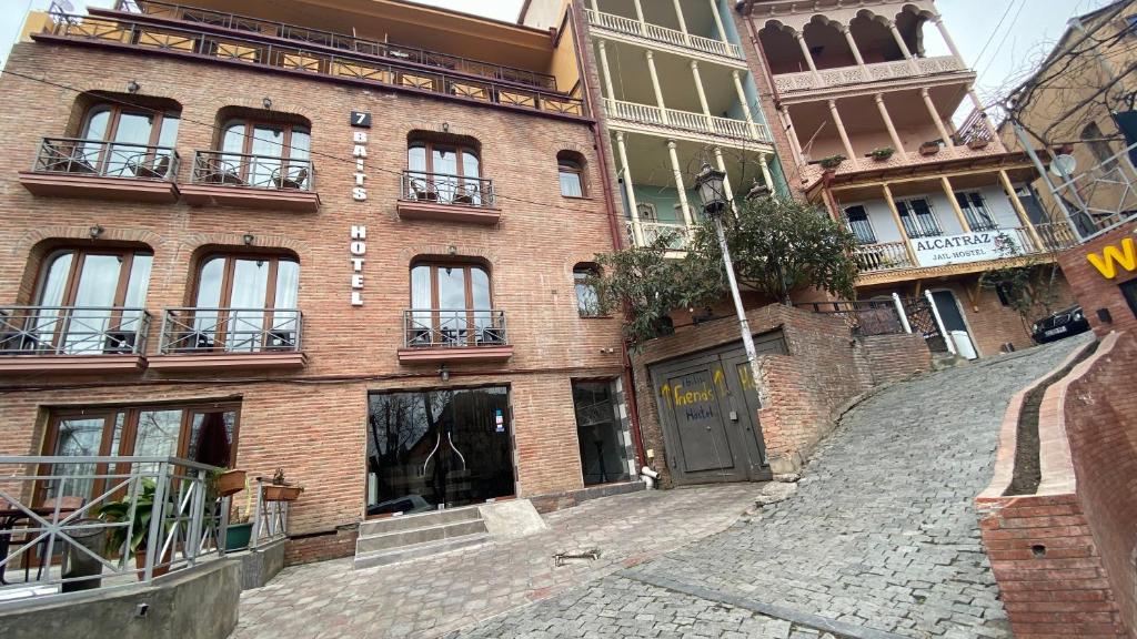 un edificio de ladrillo con una calle adoquinada delante de él en 7 Baits Hotel, en Tiflis
