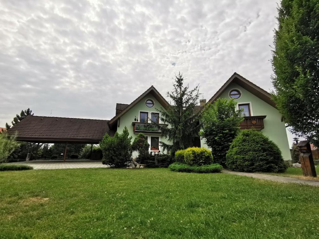 een huis met een tuin met groen gras bij Villa Capri in Nová Lesná