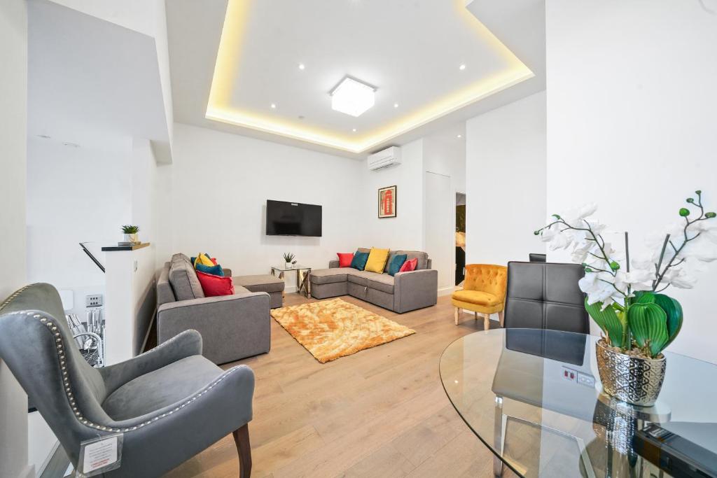 City Prime Apartments في لندن: غرفة معيشة مع كنب وطاولة زجاجية