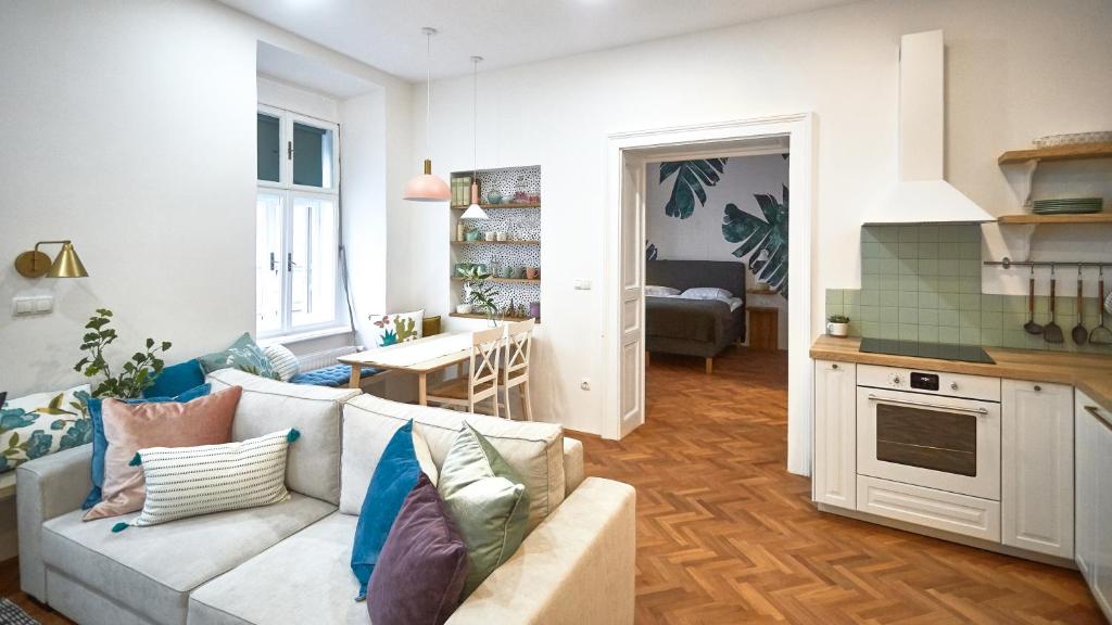 ein Wohnzimmer mit einem Sofa und einer Küche in der Unterkunft FERN apartments in Maribor