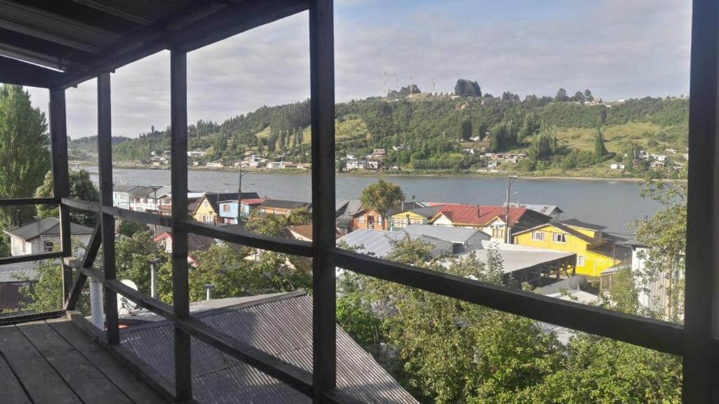 einen Balkon mit Blick auf den Fluss und die Häuser in der Unterkunft Cabaña Punta Diamante in Castro
