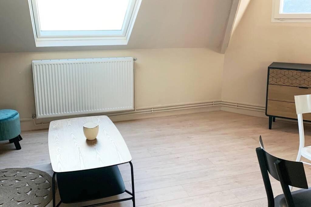 a living room with a white table and chairs at Caudry : Appartement spacieux plein centre in Caudry