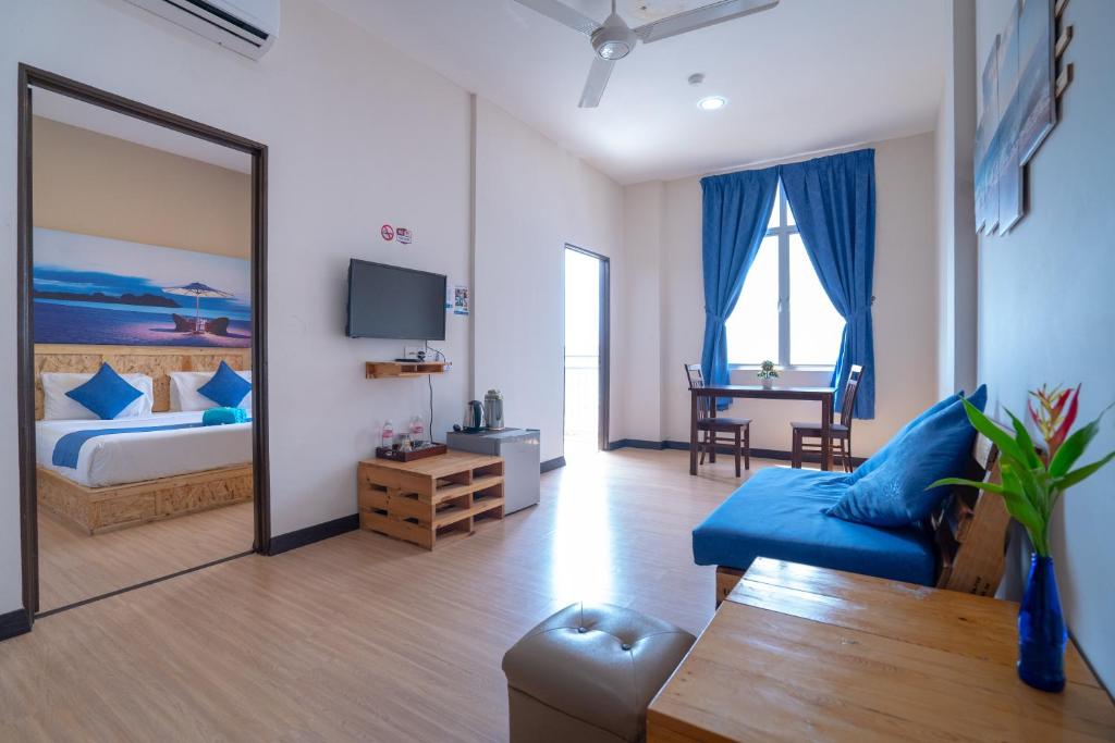 a bedroom with a bed and a living room at Paretto Seaview Hotel in Pantai Cenang