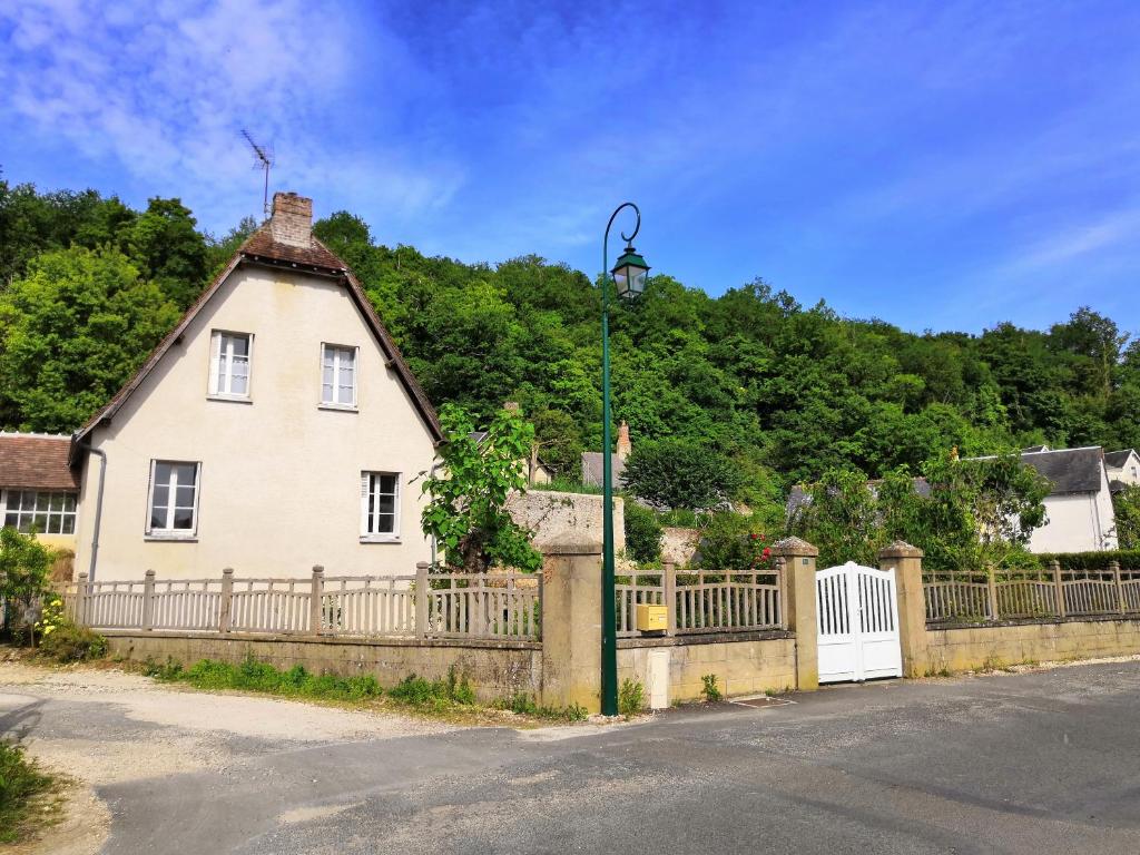 Villedieu-le-Château的住宿－Le Manoir du Gouverneur，白色的房子,有栅栏和街灯