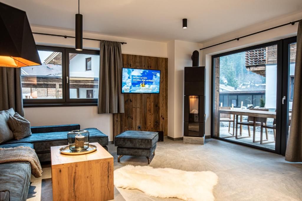Televízia a/alebo spoločenská miestnosť v ubytovaní Chalet's DAS DORF