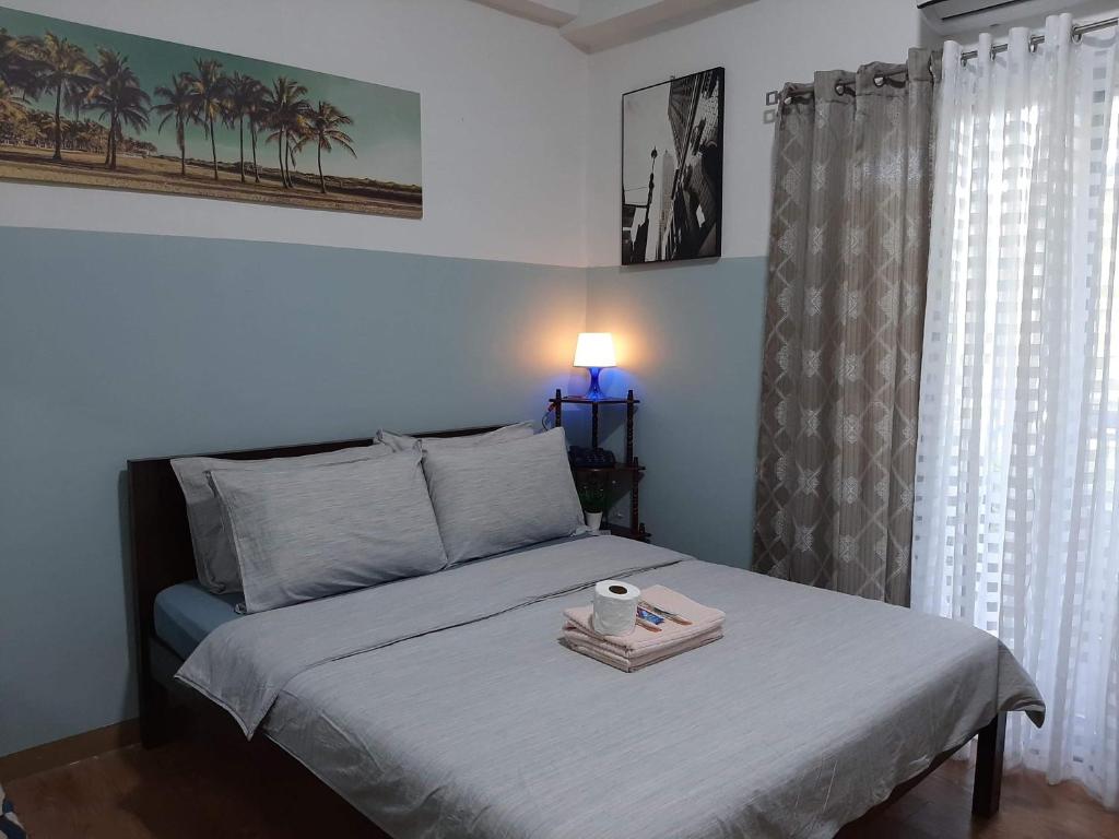 een slaapkamer met een bed en een dienblad bij Cozy condo unit 5mins from Mactan Cebu Int'l Airport with Netflix in Mactan