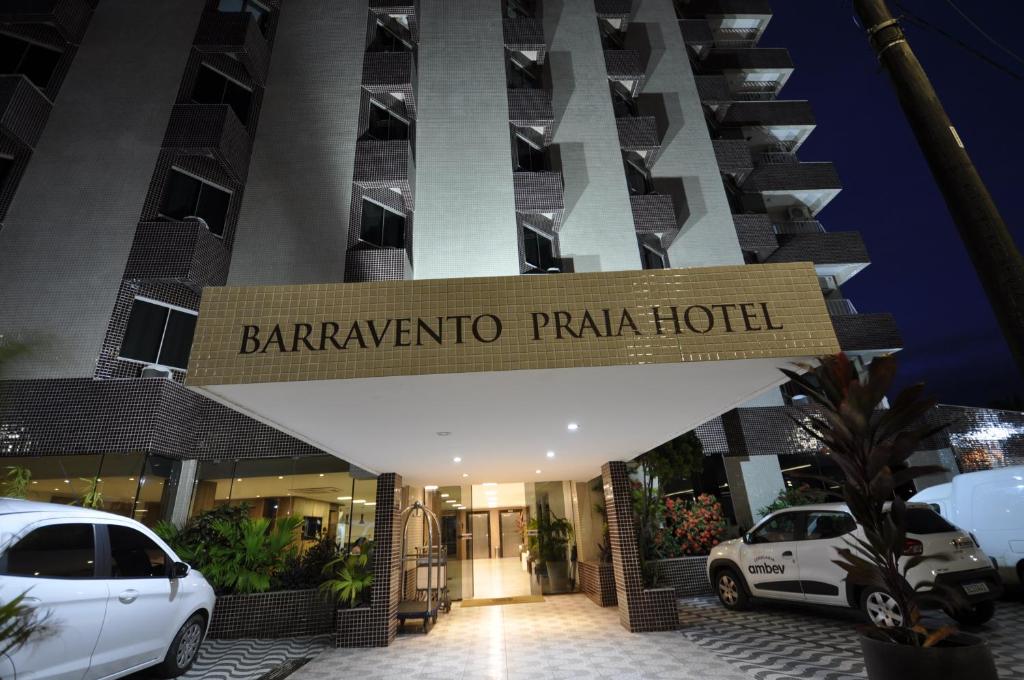 a hotel with cars parked in front of it at Barravento Praia Hotel in Ilhéus