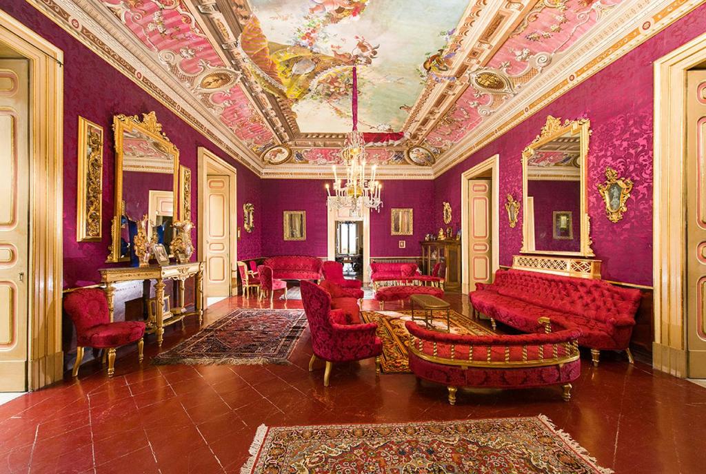 a living room with purple walls and red furniture at Dimora del Prete di Belmonte in Venafro