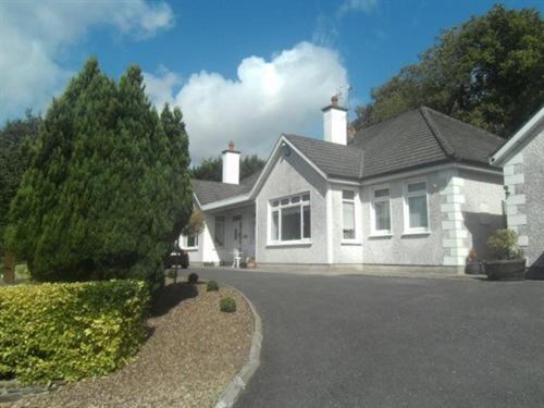 a white house with a driveway in front of it at Launard House in Kilkenny