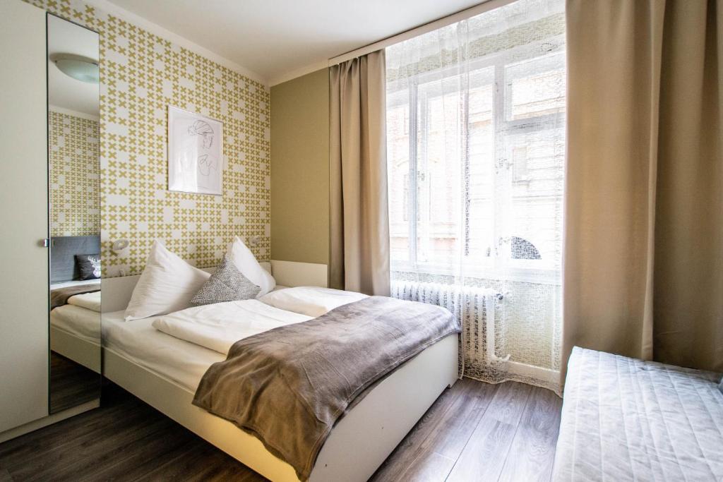 een kleine slaapkamer met een bed en een raam bij Old Town Rybna Apt by Ruterra in Praag