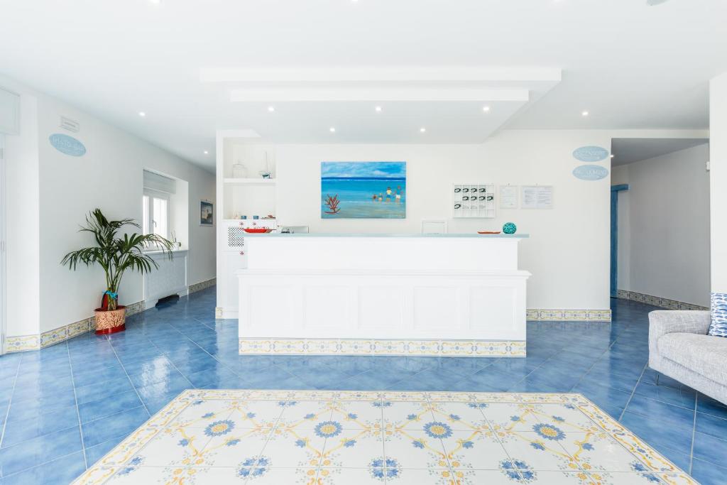 a living room with a blue tile floor and a counter at Hotel Corallo Circeo in San Felice Circeo