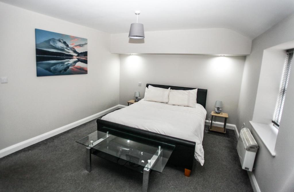 Schlafzimmer mit einem Bett und einem Glastisch in der Unterkunft No 5 New Inn Apartments in Newark upon Trent