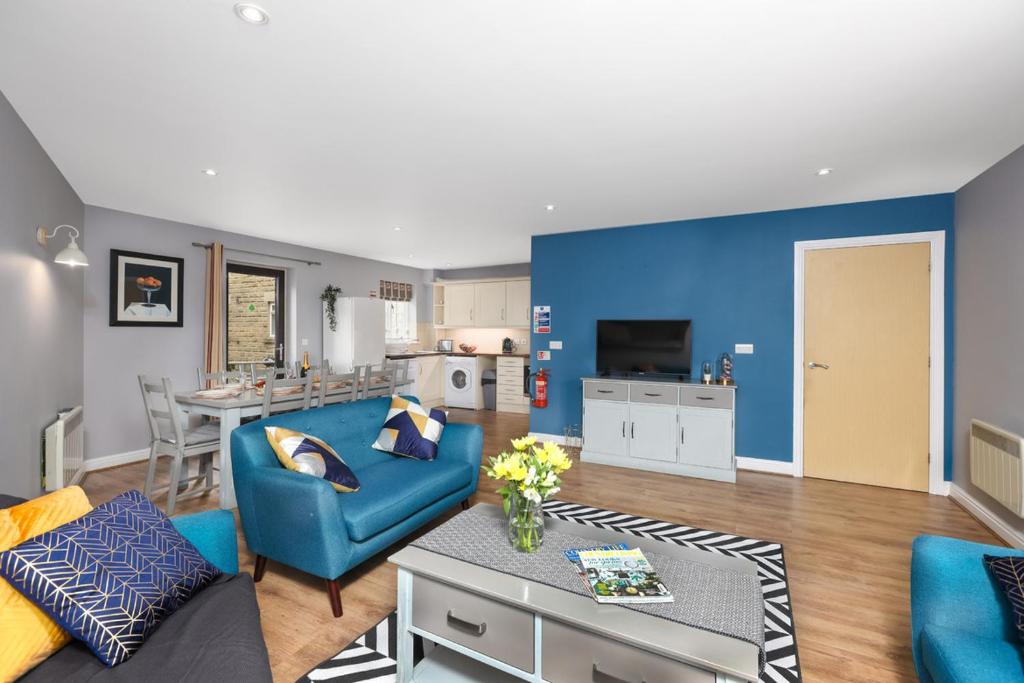 a living room with a blue couch and a table at Hopton Cottage - Darwin Lake Holiday Village in Matlock