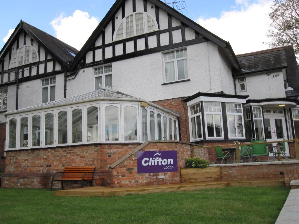 uma casa com um sinal em frente em Clifton Lodge Hotel em High Wycombe