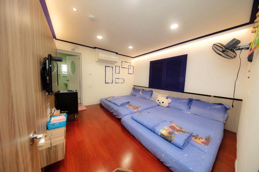 una camera da letto con un grande letto blu con cuscini blu di Liu Love B&B a Xiaoliuqiu