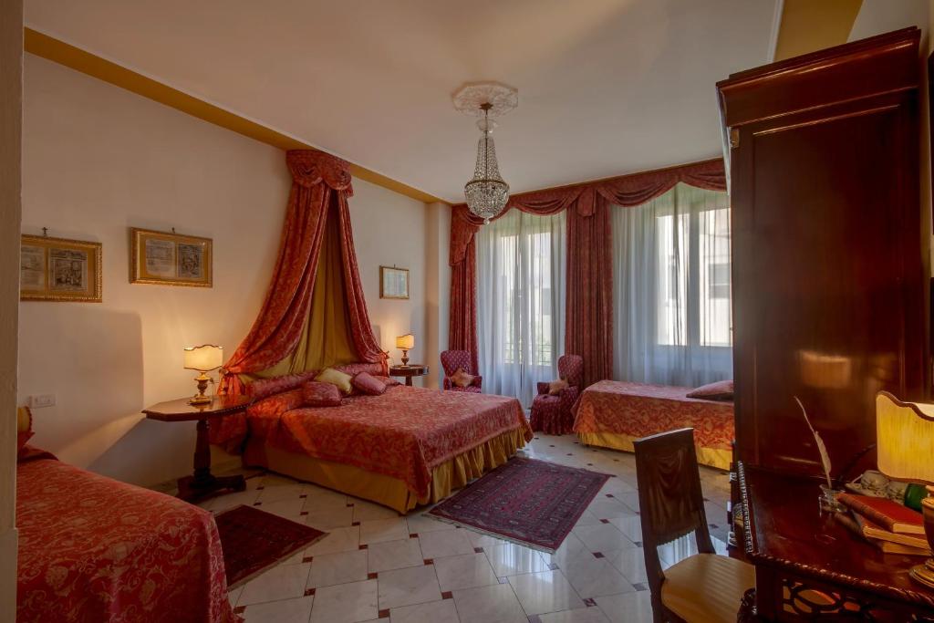 a hotel room with two beds and a chandelier at Florence Dream Domus in Florence