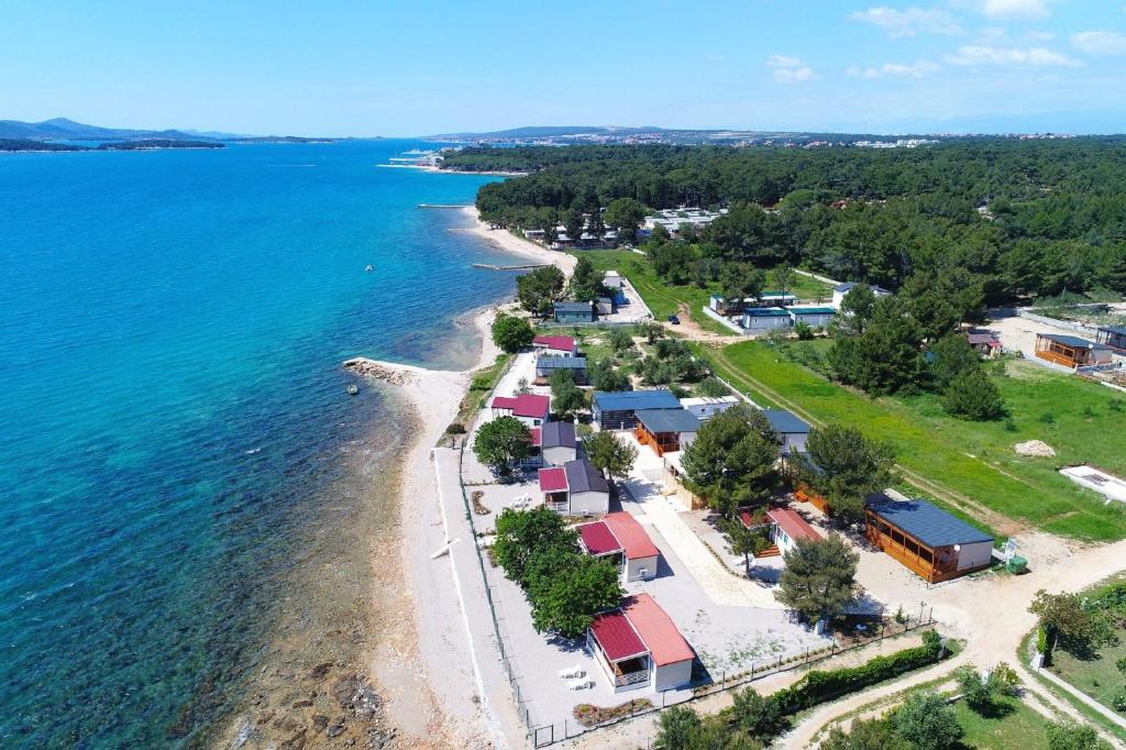 eine Luftansicht auf einen Strand mit Häusern und Wasser in der Unterkunft Mobile home Frangipani 4 in Biograd na Moru