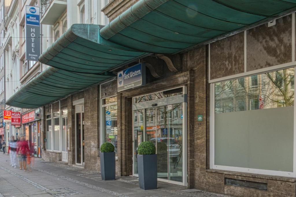 Un edificio con tenda da sole sul lato di una strada di Best Western Hotel Bremen City a Brema