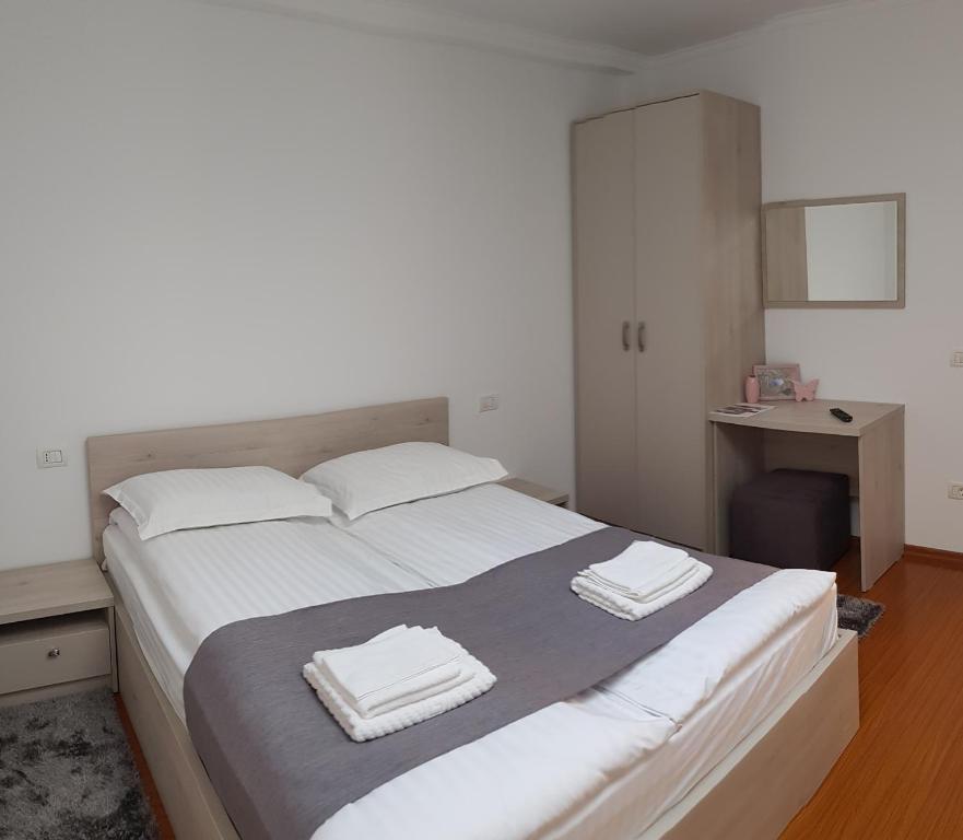 a bedroom with a large bed with two towels on it at CASA MONTIS in Borşa