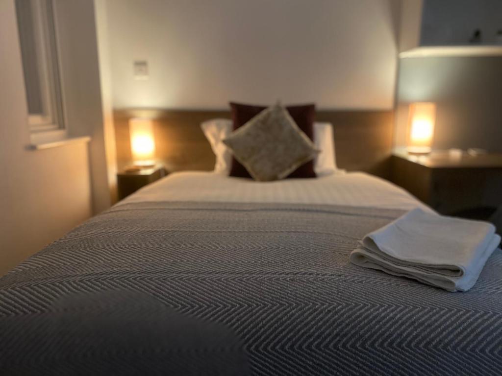 una camera da letto con un letto e due asciugamani di PS APARTMENTS a Southampton