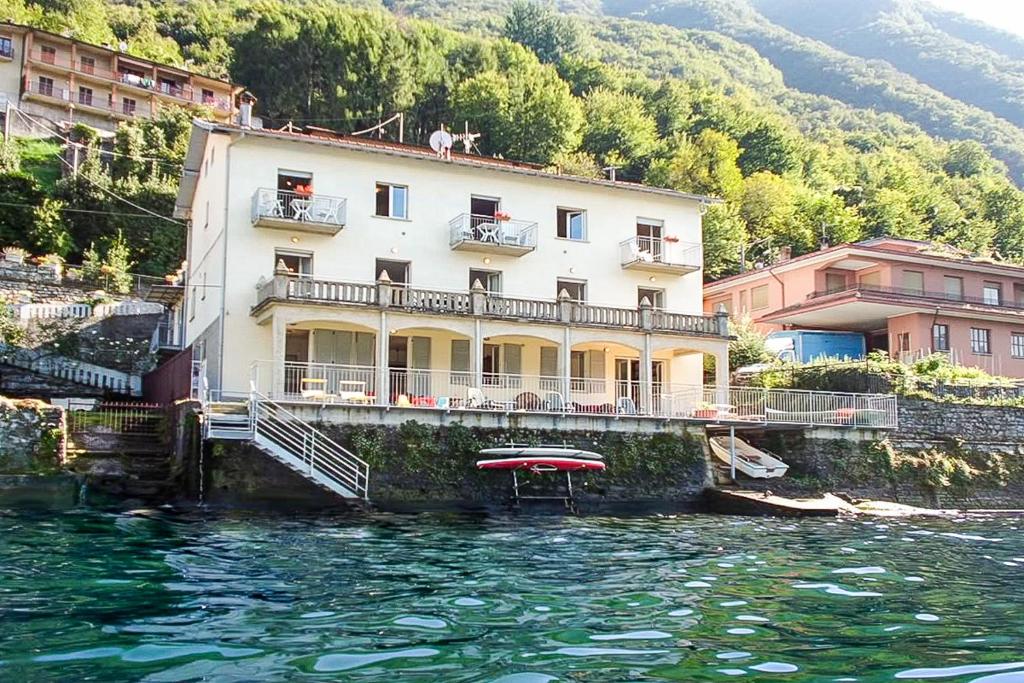 a building on the water in front of a house at Bellagio Villas in Lezzeno